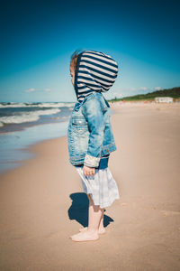 Side view of girl standing at beach