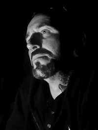 Portrait of man against black background