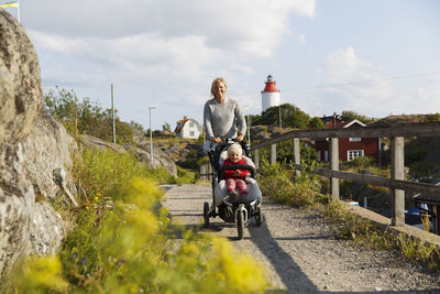 Mother pushing son in pram