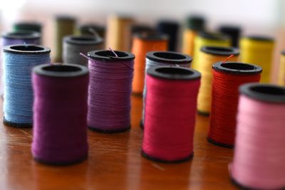 Close-up of colorful thread spools on wooden table
