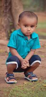 Portrait of cute boy sitting outdoors