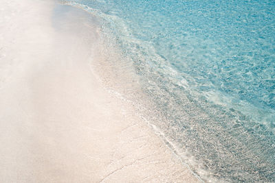 Crystal clear water rolling on white sand beach in san teodoro.