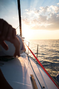 Hands over sunset during the navigation in mediterranean sea on a sail boat. sardinia, italy