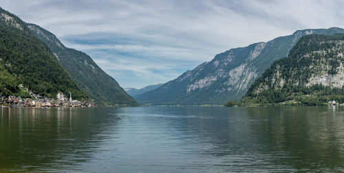 Scenic view of lake by mountains against sky