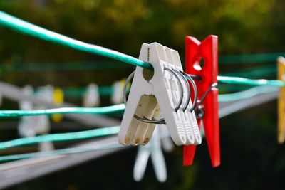 Close-up of clothespins hanging on fence
