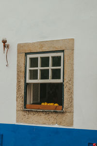 Low angle view of orange house on window of building