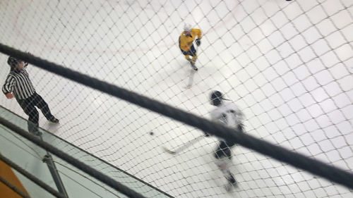 High angle view of friends playing ice hockey