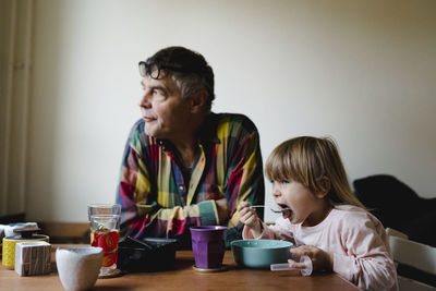 Grandfather with granddaughter at table