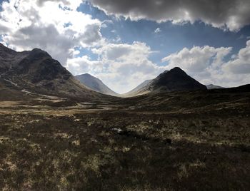 Scenic view of mountains against cloudy sky