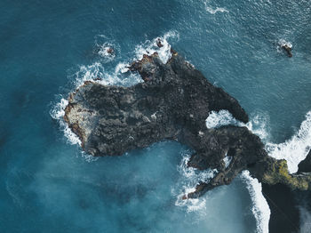 High angle view of rocks in sea against sky