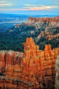 Rock formations on landscape against cloudy sky