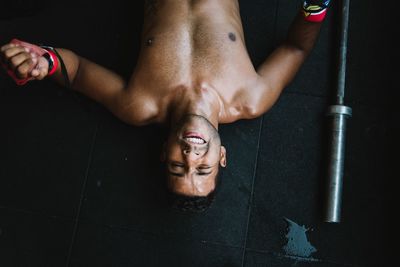 High angle view of shirtless man lying on floor