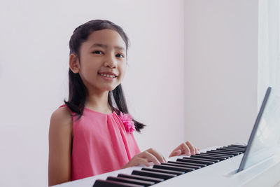 Portrait of smiling girl playing piano