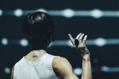 Rear view of woman standing against blurred background