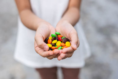 Cropped image of hand holding candies