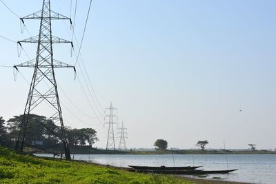 Low angle view of electricity pylon against clear sky
