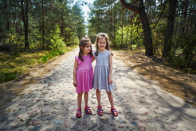 Portrait of smiling girl standing against trees