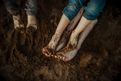 Low section of women standing on mud