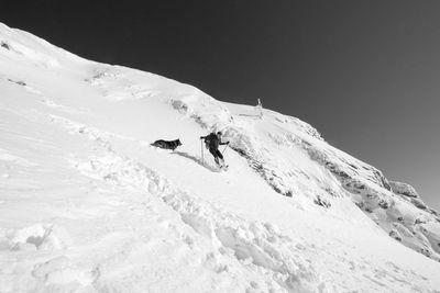 Low angle view of senior man skiing on snow covered mountain against sky