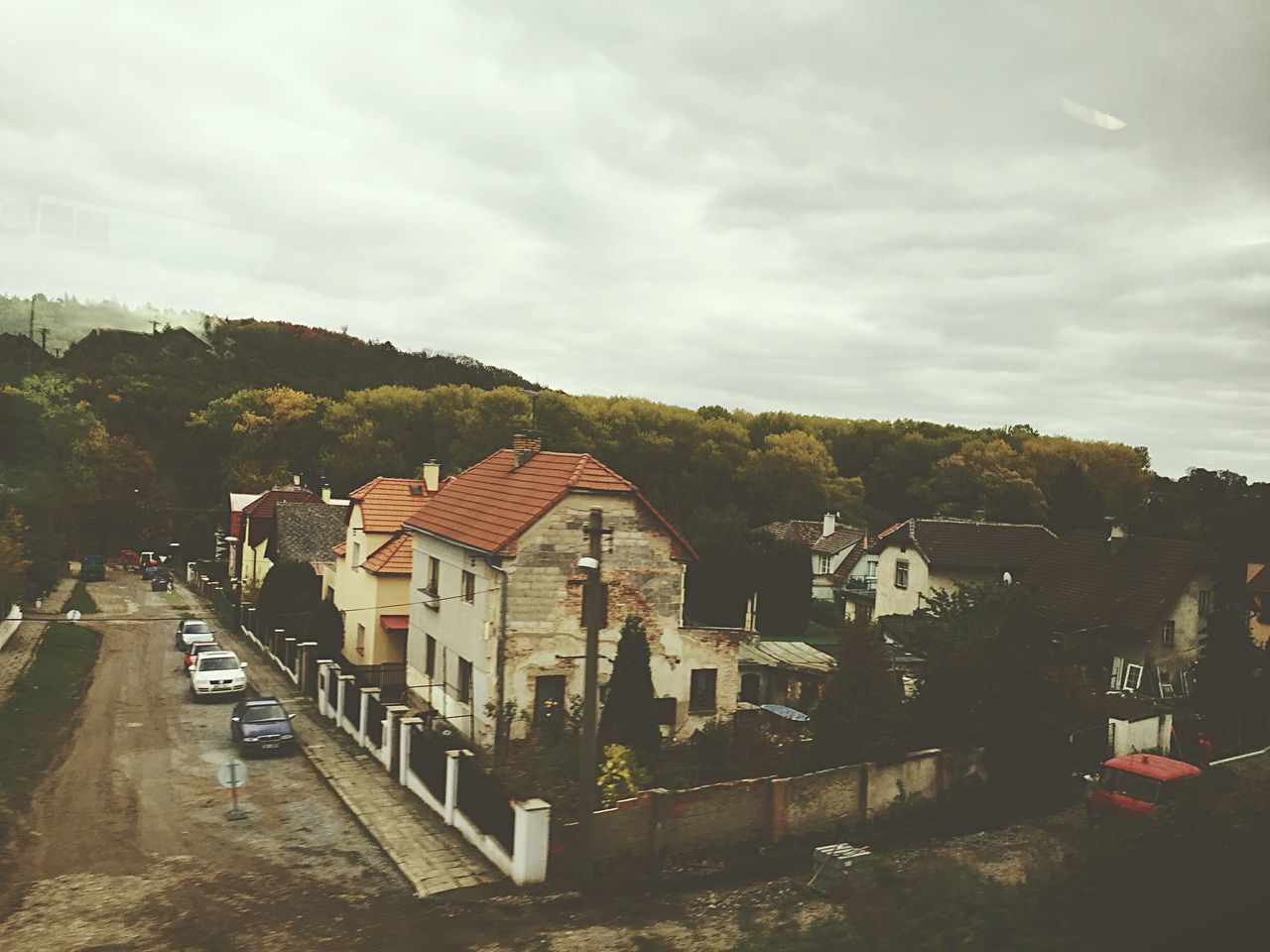 building exterior, architecture, built structure, sky, cloud - sky, residential structure, house, residential building, street, transportation, tree, car, cloudy, residential district, road, city, high angle view, cloud, town, land vehicle