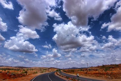 Road passing through landscape against sky