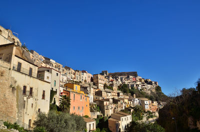 Low angle view of buildings against clear blue sky