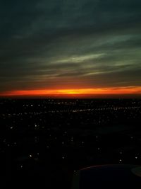 Illuminated cityscape against sky during sunset