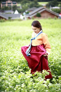 Woman looking down while standing by plants