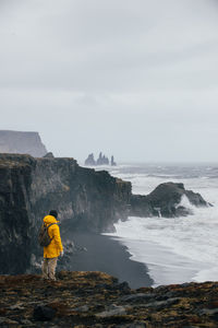 Man on cliff by sea