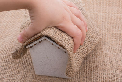 Close-up of hand holding jute over model home