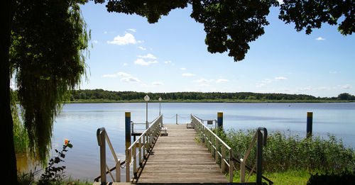 Wooden pier over lake against sky