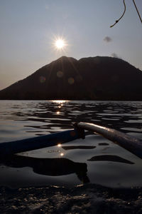 Scenic view of lake and mountains against sky during sunset