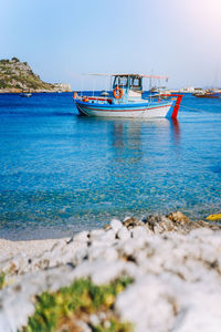 Boat moored on sea against sky