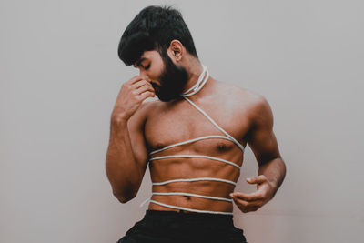 Young man standing against white background