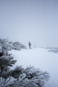 Man on snow covered landscape against clear sky