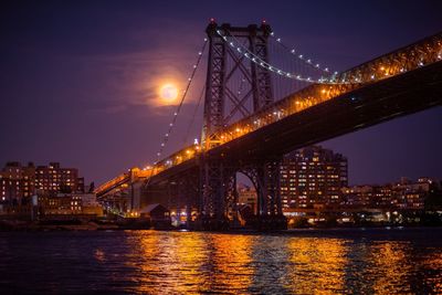 Suspension bridge over river at night