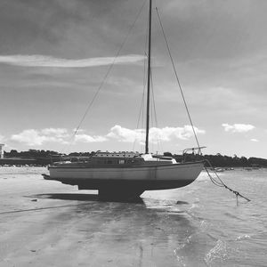 Sailboats moored on sea against sky