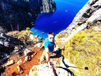 High angle view of man standing on rock by sea