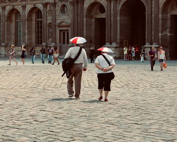 Rear view of people walking on street