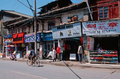 People on street against buildings in city