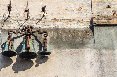 Detail of three ancient iron bells hanging on a wall of the castel sant'angelo