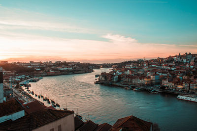 High angle view of river and buildings against sky during sunset