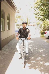 Side view of man riding bicycle on street