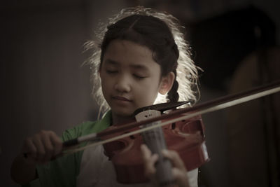 Girl playing violin indoors