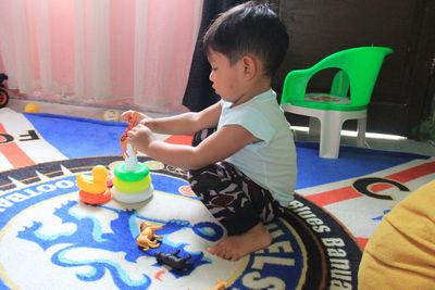 Boy playing with toy sitting on table