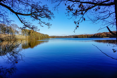 Scenic view of lake against clear blue sky