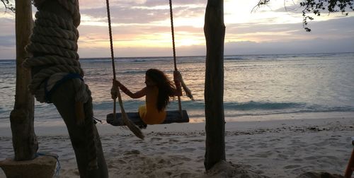 People on beach against sky during sunset
