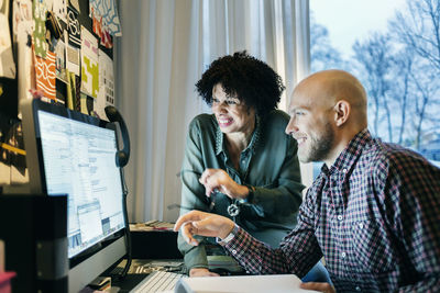 Happy business people working on computer in office