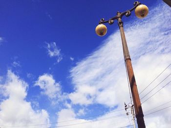 Low angle view of street light against blue sky