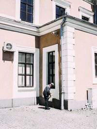 Full length of man standing against building in city